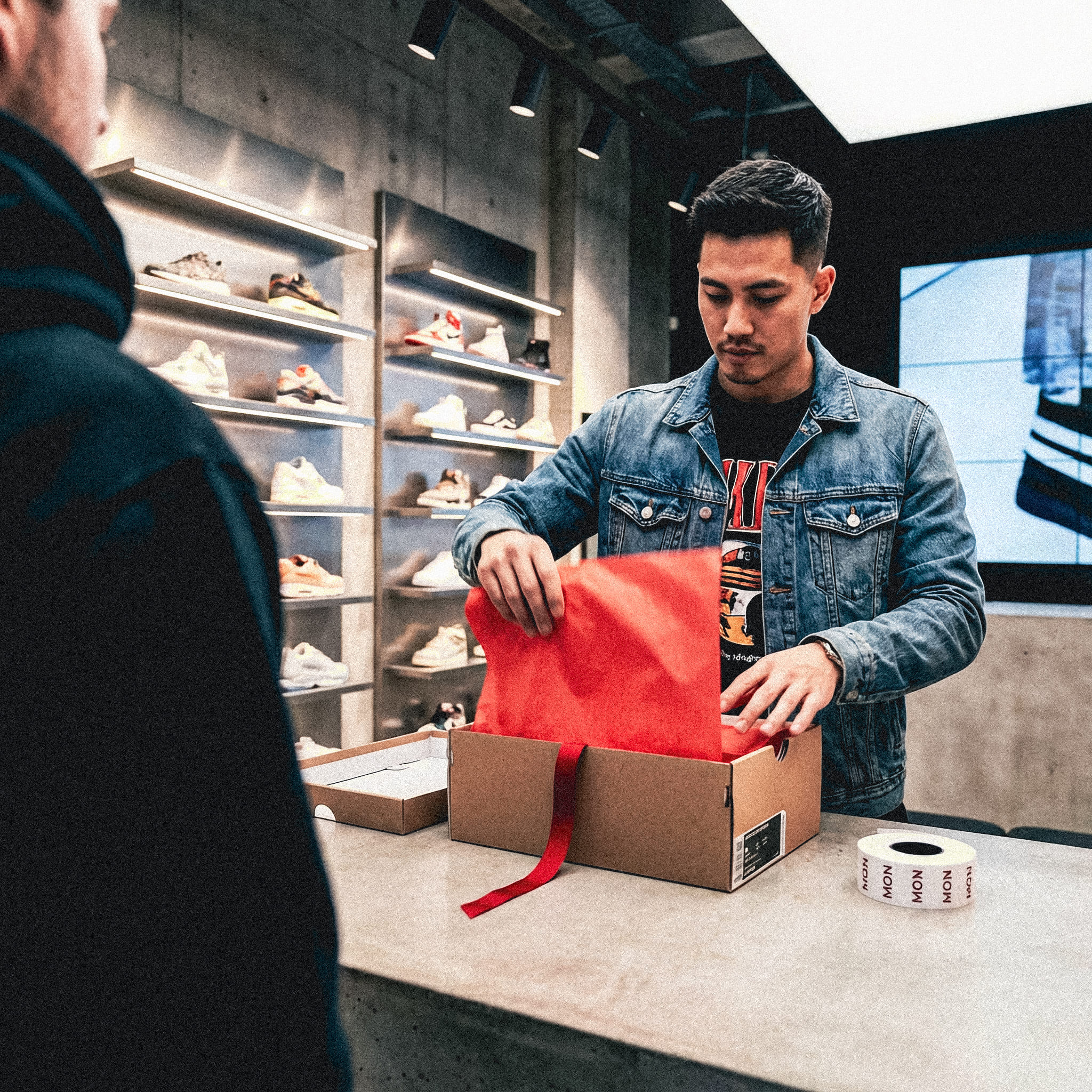 Firefly_Gemini Flash_Create a full-colour urban fashion retail photo set in a modern flagship sneaker stor 342692